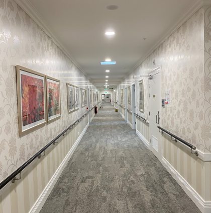 Long corridors of 2 wallpapers one above and one below a dado rail in aged care