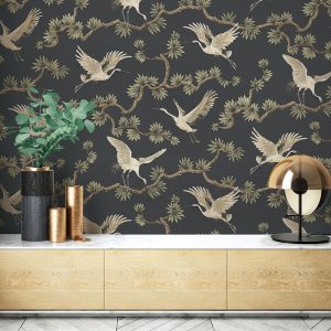 Cranes flying from leafy branches on a black backdrop feature in thie wallpaper by wallquest