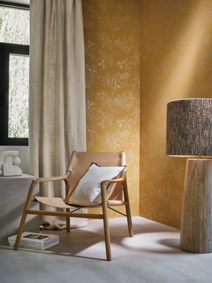 Living space with mustard ochre colooured wallpaper of coral with cranes