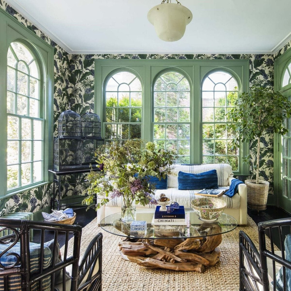Beautiful sunroom living area including jungle leaf wallpaper with parrots