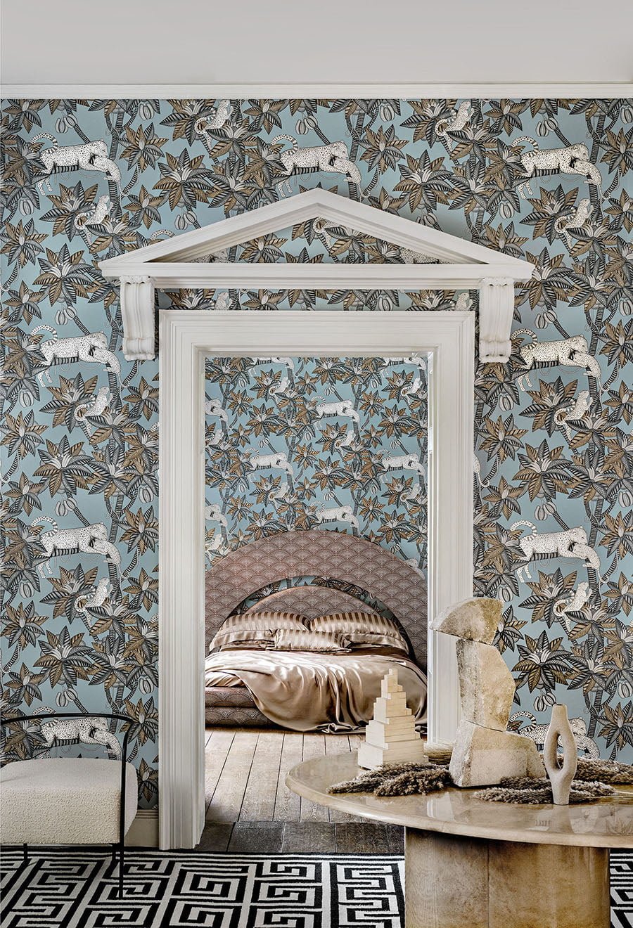 A fun room with powder blue wallpaper of palm trees with leopards