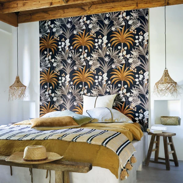 A boho chic bedroom with a panel of Mirissa tropical tree wallpaper