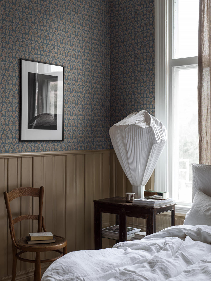 A traditional wallpaper above timber panel in blue art nouveau style