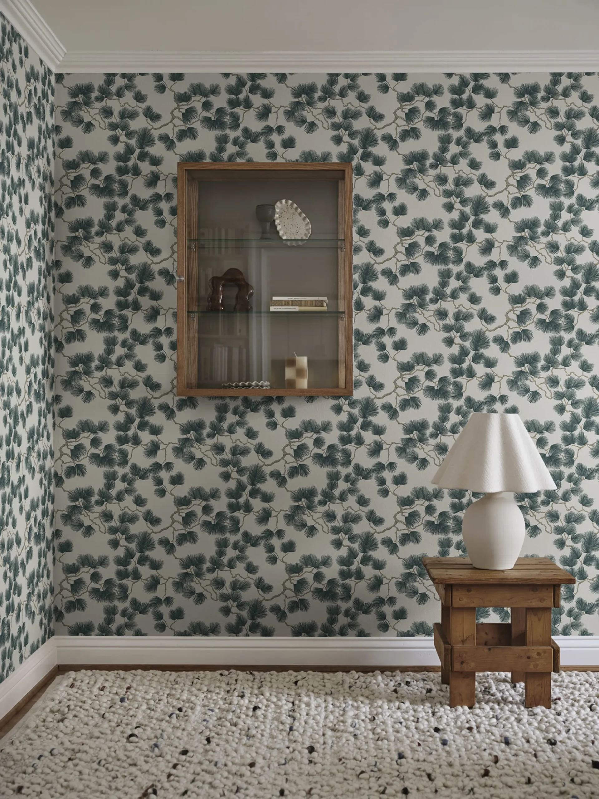 Pine leaves feature in green in this wallpaper in a rustic room